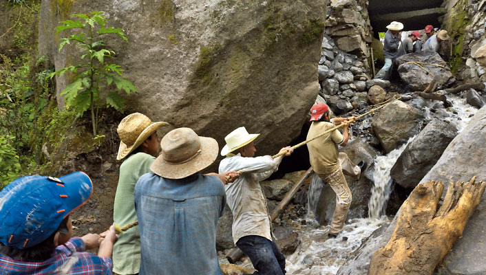 Wenn es in den Bergen von Chichicaxtepec in Mexiko ein Unwetter gibt, machen die Niederschläge kleine Bäche zu tobendem Wildwasser, das selbst riesige Felsbrocken mit sich reißt. Ein Brocken blieb genau unter der Brücke liegen. Beim nächsten Gewitter werden sich Äste vor dem Fels verkeilen, das Wasser wird sich aufstauen und am Ende die Brücke wegreißen. Deshalb legen die Bauern gemeinsam Hand an: „Eins, zwei und los!“ (Foto: Uli Reinhardt)